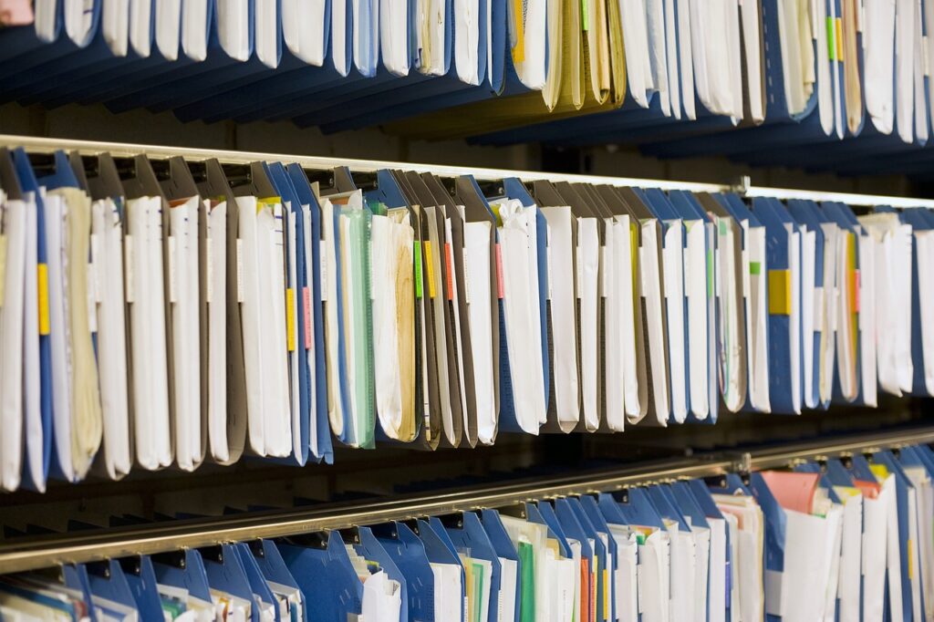 Gérer les archives hospitalières, dossiers d'archives rangés sur le rayonnage