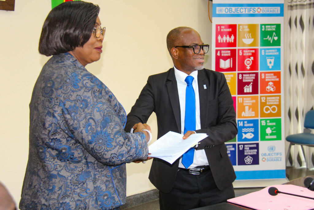 La Ministre de la Fonction Publique et du Travail et le Représentant Résident du PNUD au Bénin échangeant les parapheurs à la suite de la signature du document de projet de digitalisation des services publics au Bénin