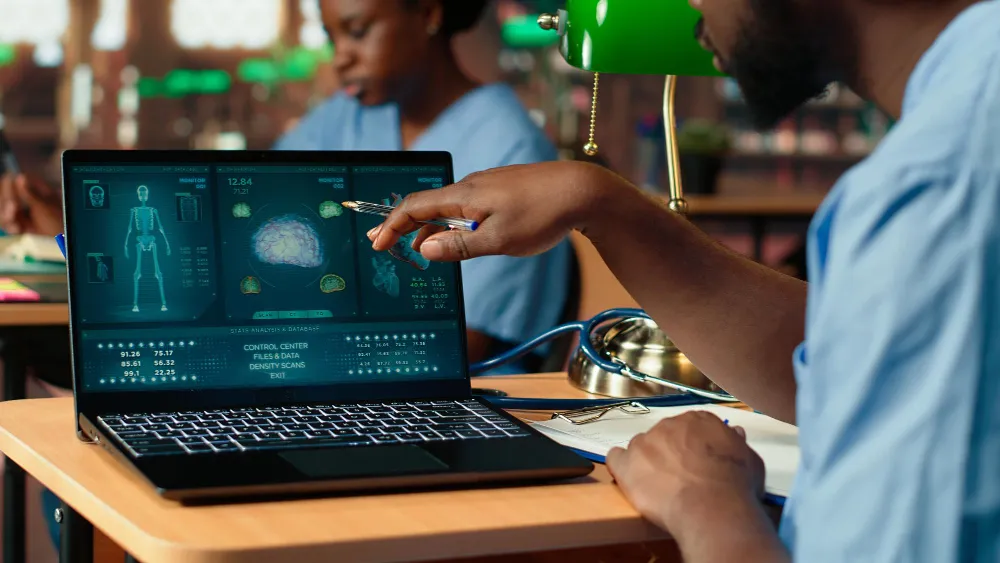 Un chercheur noir de l'école de médecine étudie et prend des notes en utilisant l'Africa Health Knowledge Management Portal (continental, régional, national)